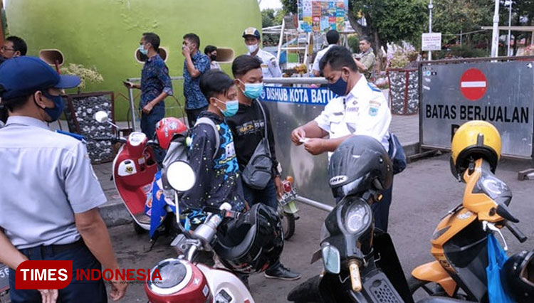 Petugas Dinas Perhubungan saat melakukan sosialisasi E Parking di seputar Alun-Alun Kota Batu. (foto: Muhammad Dhani Rahman/TIMES Indonesia)