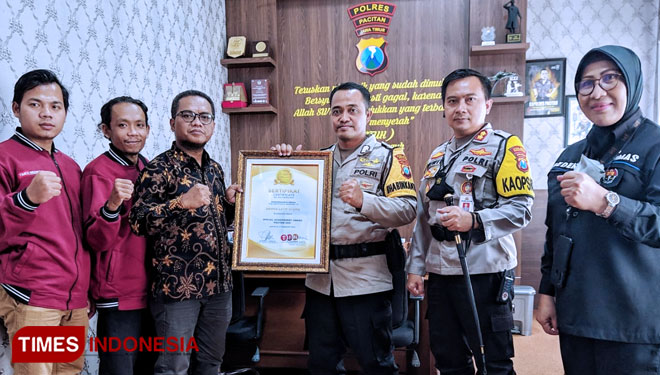 Bripka Latip Utomo menerima Anugerah TIMES Indonesia 2021 kategori special achievement award bidang pengabdian masyarakat, didampingi Kapolres Pacitan AKBP Wiwit Ari Wibisono dari Direktur TIMES Indonesia Bambang H Irwanto. (FOTO: Humas Polres Pacita