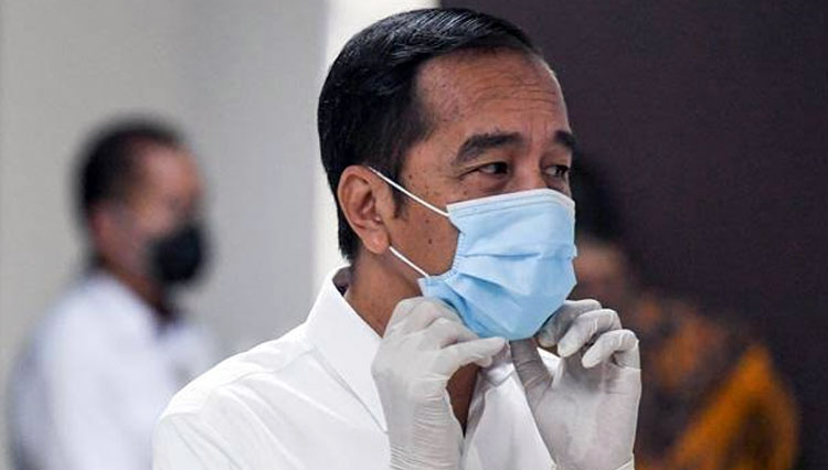 Presiden RI Jokowi memperbaiki masker saat berkunjung ke Wisma Atlet, Kemayoran, Jakarta. (FOTO: Antara)