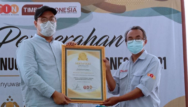 Adriel Danny Kurniawan mewakili Ketua DPC Partai Demokrat Banyuwangi, Michael Edy Hariyanto, menerima penghargaan Anugerah TIMES Indonesia (ATI) 2021 dari Wakil Pimpinan Redaksi TIMES Indonesia, Wahyu Nurdianto. (Foto : Dokumentasi TIMES Indonesia)