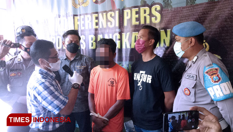 Kasatreskrim Polres Bangkalan, AKP Sigit Nursiyo Dwiyugo menginterogasi NS yang tega membunuh pamannya gara-gara isu santet. (FOTO: Doni Heriyanto/TIMES Indonesia)
