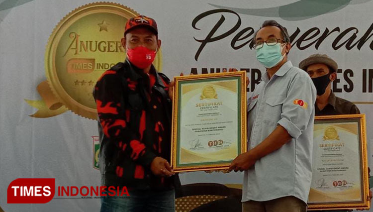 Zamroni SH, Ketua MPC Pemuda Pancasila Banyuwangi saat menerima penghargaan Anugerah TIMES Indonesia (ATI) 2021 dari Wakil Pimpinan Redaksi TIMES Indonesia, Wahyu Nurdianto. (Foto : Dokumentasi TIMES Indonesia).
