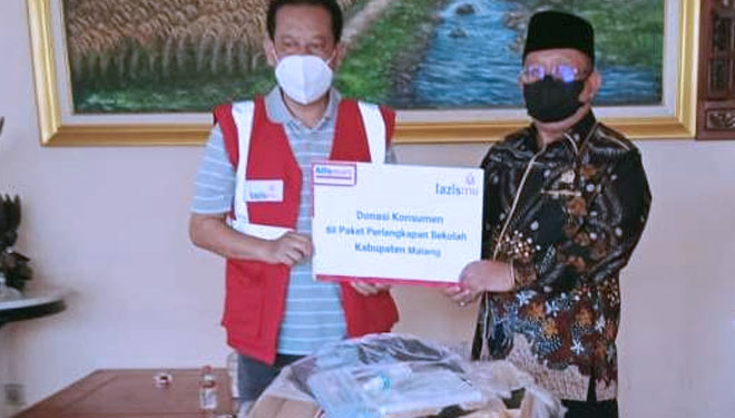 Regional Corcom Manager PT Sumber Alfaria Trijaya Tbk Mochammad Faruq Asrori secara simbolis menyerahkan bantuan perlengkapan sekolah kepada Hadi Mustofa, penasehat Paguyuban Pedagang Pasar Kabupaten Malang (P3KM). (Foto-foto: Alfamart for TIMES Indo