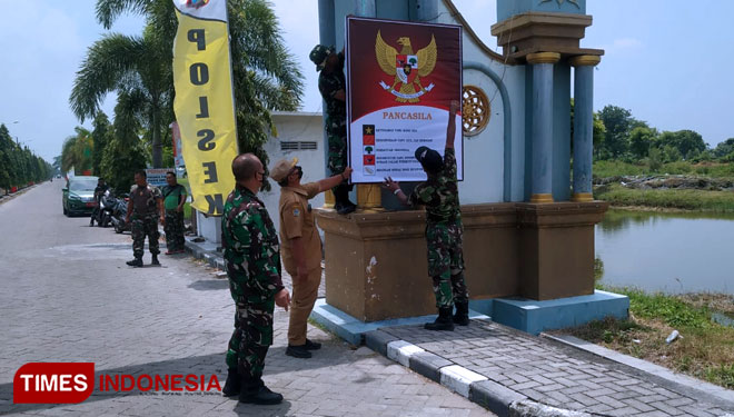 Pemasangan baner bertema Pancasila di gapura desa. (Foto: Akmal/TIMES Indonesia)