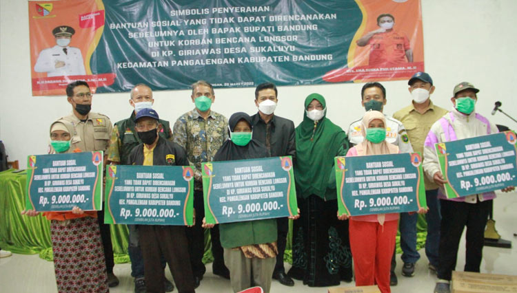 Bupati Bandung Dadang Supriatna menyerahkan bantuan untuk korban terdampak longsor di Kp Giriawas Desa Sakaluyu Kec Pangalengan Kab Bandung, Minggu (20/3/2022) sore.