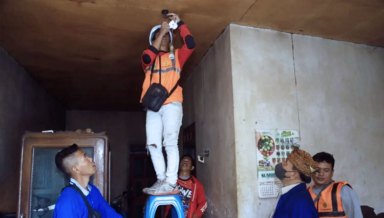Petugas pasang listrik di rumah Kasun Ngelosari, Desa Sapikerep Kecamatan Sukapura, Kabupaten Probolinggo. (FOTO: Diskominfo Kabupaten Probolinggo)