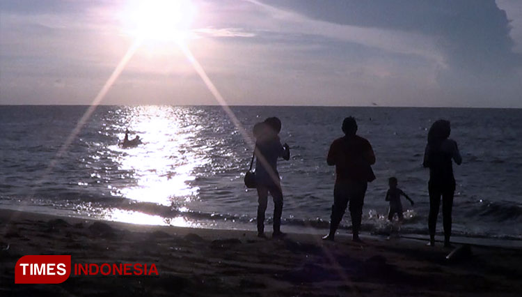 Pengunjung di Pantai Duta sedang menikmati senja di sore hari. (FOTO: Dicko W/TIMES Indonesia)