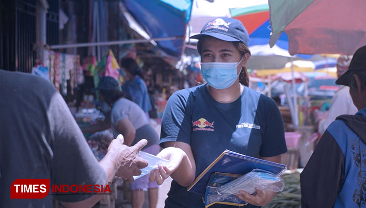 Sales Promotion Girls Ajeng Putri Alia saat memberikan edukasi dan membagikan masker kepada pengunjung Pasar Rakyat Tondano, Selasa (5/4/2022) siang. (FOTO: Harniwan Obech/TIMES Indonesia)