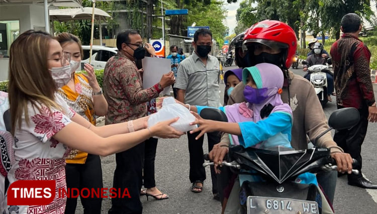 Tim PT Midtou Aryacom Futures berbagi takjil kepada pengendara di sepanjang Jalan Boulevard Surabaya, Senin (18/4/2022). (Foto: Lely Yuana/TIMES Indonesia)