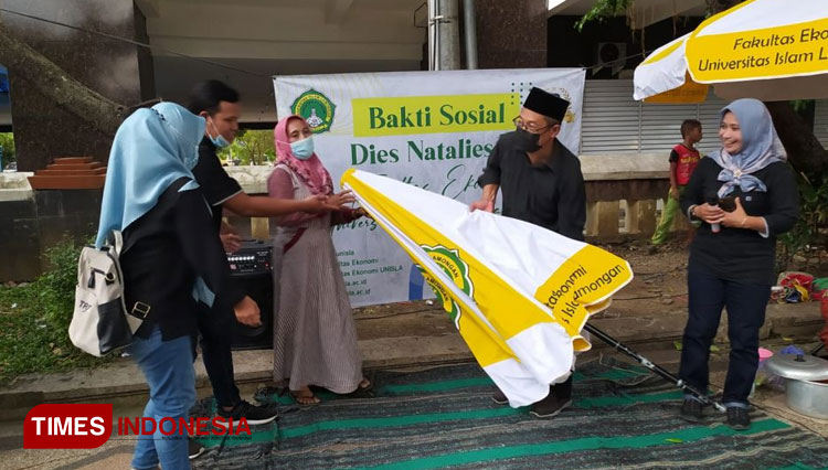 Rektor Unisla, Bambang Eko Muljono, secara simbolis menyerahkan tenda payung kepada penjual nasi borang yang berjualan di belakang Gedung Pemkab Lamongan, Selasa, (26/4/2022). (Foto: Ja’far Shodiq (CR-161)/AJP TIMESINDONESIA)