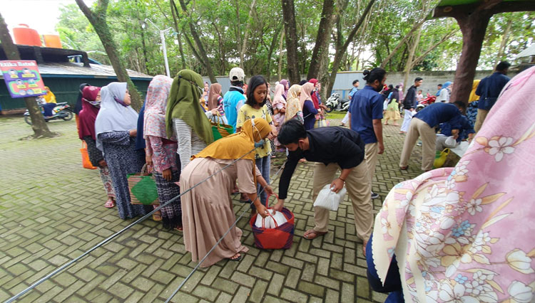 Petugas PT WSI- Pantai Cahaya Sikucing, saat membagikan bingkisan kepada warga Desa Sindang Sikucing di wisata Pantai Sikucing, Kamis (28/4/2022) petang. (FOTO: Humas PT WSI Pantai Cahaya)