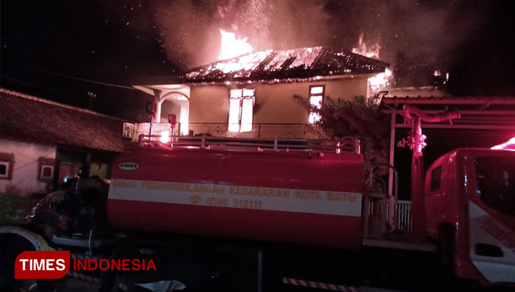 Petugas PMK Kota Batu berjibaku memadamkan api yang membakar rumah Mak Sutik. (FOTO: Muhammad Dhani Rahman/TIMES Indonesia)