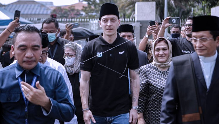 Pesepak bola klub Fenerbahce SK Mesut Oezil (tengah) tiba di Masjid Istiqlal Jakarta, Jumat (27/5/2022). (FOTO: ANTARA FOTO/Fauzan)