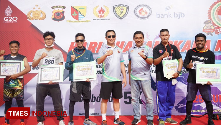 Kapolresta Bandung Kombes Pol Kusworo Wibowo membagikan hadian untuk para juara lomba lari 5 km kategori wartawan, di Lapangan Upakarti, Kabupaten Bandung, Sabtu (25/6/2022). (Foto: Iwa/TIMES Indonesia)