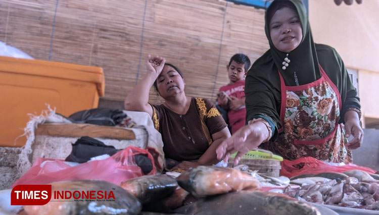 Pedagang ikan laut di Pasar Arjowinangun, Pacitan keluhkan harga yang kian melonjak. Tampak raut wajahnya tak berseri khawatir rugi. (FOTO: Yusuf Arifai/TIMES Indonesia)