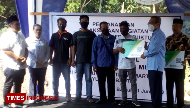Secara simbolis, Bupati Bantul Abdul Halim Muslih menyerahkan kartu tanda peserta BPJS Ketenagakerjaan kepada perwakilan peserta Program Padat Karya Infrastruktur BKK Tahun 2022. (FOTO: Totok Hidayat/TIMES Indonesia)