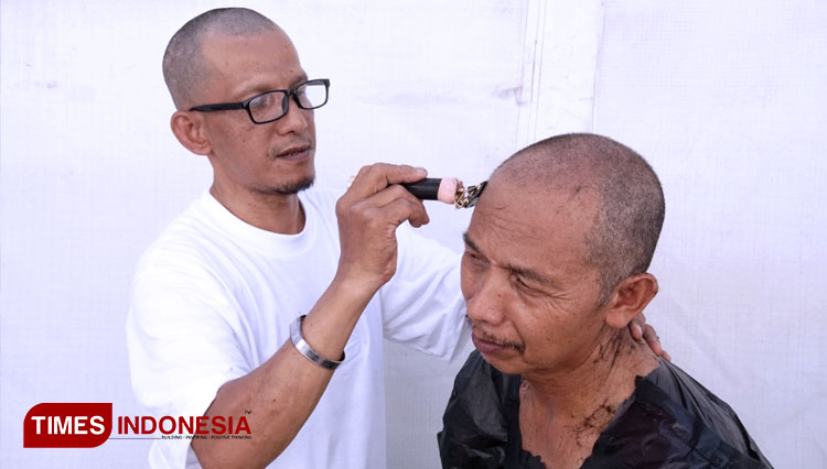 Salah satu jemaah saat tahallul, cukur gundul di sebelah tenda di Mina. (FOTO: MCH 2022/TIMES Indonesia).