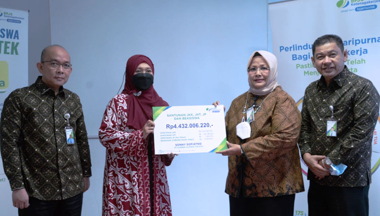 Direktur Pelayanan BPJS Ketenagakerjaan (BPJamsostek), Roswita Nilakurnia, saat menyerahkan santunan kepada peserta jaminan sosial. (Foto: Dokumentasi TIMES Indonesia)