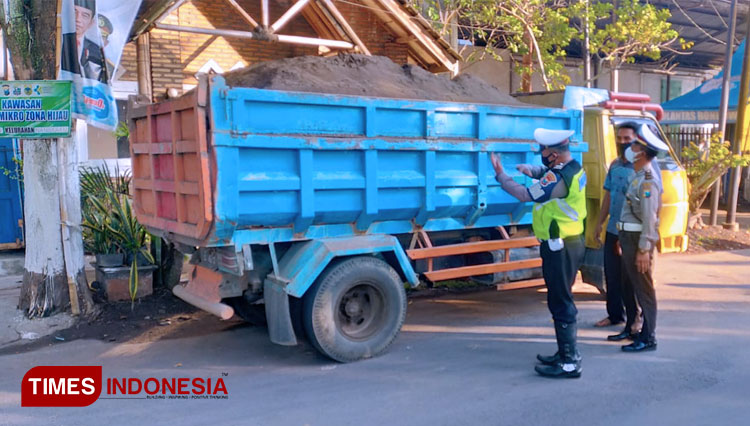 Petugas dari Satlantas Polres Bondowoso saat menindak truk pengangkut pasir tanpa penutup atau terpal (FOTO: Moh Bahri/TIMES Indonesia)