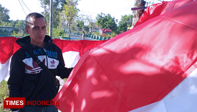 Pedagang saat memegang atribut bendera merah putih di pinggir jalan Trunojoyo Pamekasan. (Foto: Akhmad Syafi'i/TIMES Indonesia)