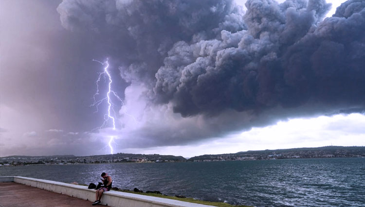 Masih ada petir menyambar asap dari tangki penyimpanan bahan bakar yang meledak di dekat pelabuhan supertanker Kuba di Matanzas, Kuba. (FOTO A: Reuters)