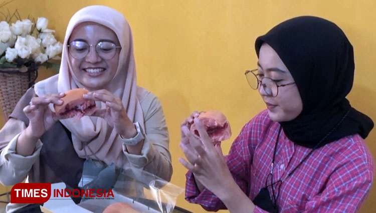 Pembeli saat mencicipi roti gembung juara (FOTO: Akmal/TIMES Indonesia)