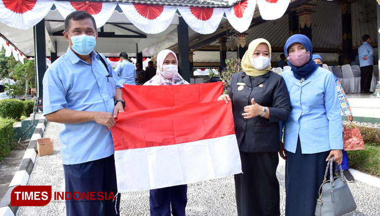 Bupati Sleman Kustini SP ketika membagikan bendera merah putih kepada penyuluh KB. (FOTO: Fajar Rianto/TIMES Indonesia)