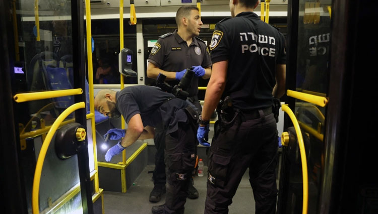 Petugas kepolisian Israel memeriksa bus yang menjadi sasaran orang-orang bersenjata. (FOTO: Ahmad Gharabli/AFP)