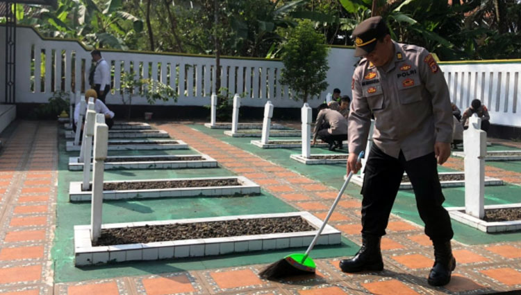 Personel Polres Tasikmalaya membersihkan Taman Makam Pahlawan  KH Zainal Musthafa di Kecamatan Sukarame, Senin (15/8/22) (FOTO: Dok. Polres Tasikmalaya)