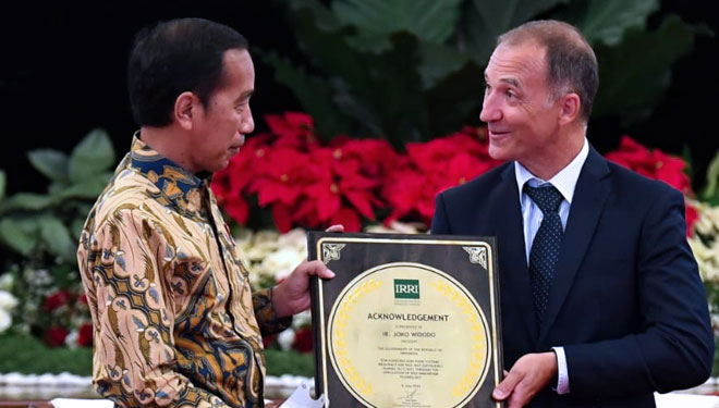 Presiden Joko Widodo menerima penghargaan IRRI atas keberhasilannya pada sistem ketahanan pangan Indonesia dari Direktur Jenderal IRRI Jean Balie di Istana Negara, Jakarta, Minggu (14/08/2022) - (FOTO: dok BPMI Setpres)