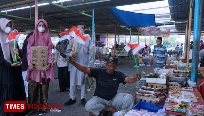 Pedagang saat diberikan bendera oleh siswa SMA Muhammadiyah 10 GKB Gresik (Foto: Akmal/TIMES Indonesia).