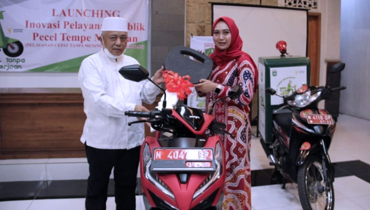 Bupati Malang Sanusi ketika memberikan apresiasi kepada Kades Senggreng yang menciptakan inovasi pelayanan publik Pecel Tempe Mendoan. (FOTO: Prokopim Kabupaten Malang)