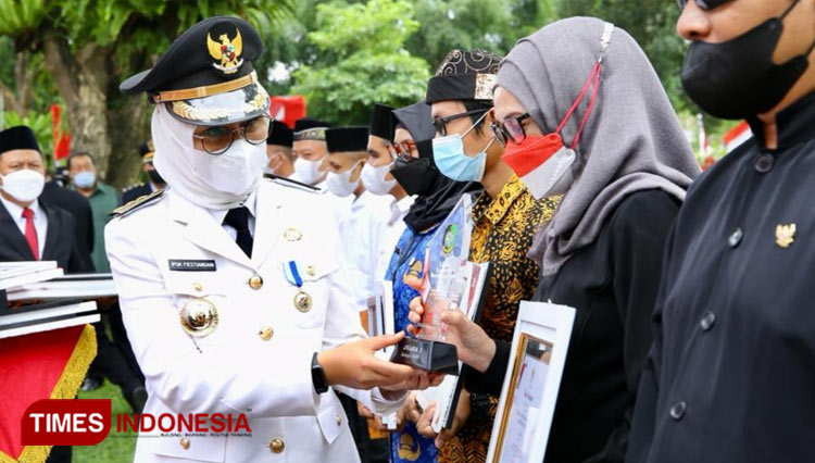 Bupati Banyuwangi, Ipuk Fiestiandani Azwar Anas, saat menyerahkan piagam penghargaan juara I Lomba Kantorku Bersih dan Asri Tahun 2022, untuk kategori SKPD, kepada Direktur RSUD Genteng, dr Siti Asiyah Anggraeni, M.MRS. (Foto : Dokumentasi TIMES Indo