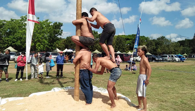 Tim lomba panjat pinang saling bahu membahu menuju puncak kemenangan dalam Festival Salam Satu Jiwa Indonesia di Lapangan Brawijaya Rampal Kota Malang, Rabu (17/8/2022). (Foto: Dok.Penrem 083/Bdj) 