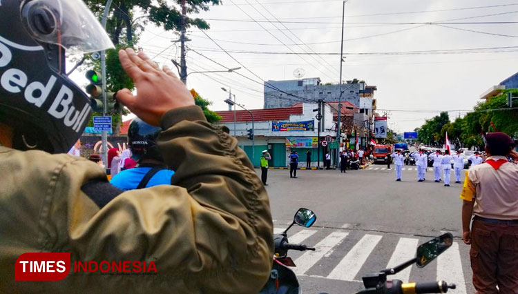 Pengendara memberi hormat kepada bendera merah putih di simpang empat A Yani Kota Madiun. (Foto: Yupi Apridayani/TIMESIndonesia)