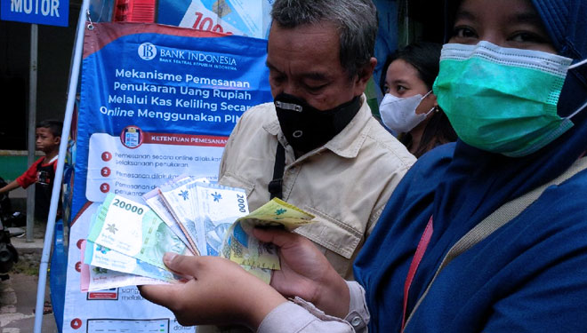 Warga menunjukan hasil penukaran uang baru di gerai Bank Indonesia. (FOTO: dok TIMES Indonesia)
