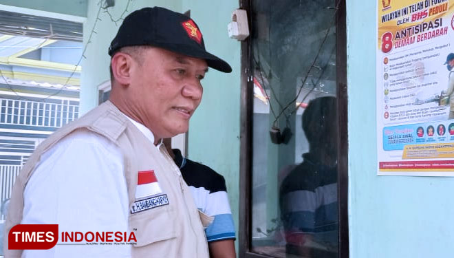 Bambang Haryo saat menempelkan poster penanggulangan, pencegahan dan antisipasi penyebaran DBD di Balai RW Desa Kramat Jegu, Kecamatan Taman, Sidoarjo (Rudi Mulya/TIMES Indonesia)