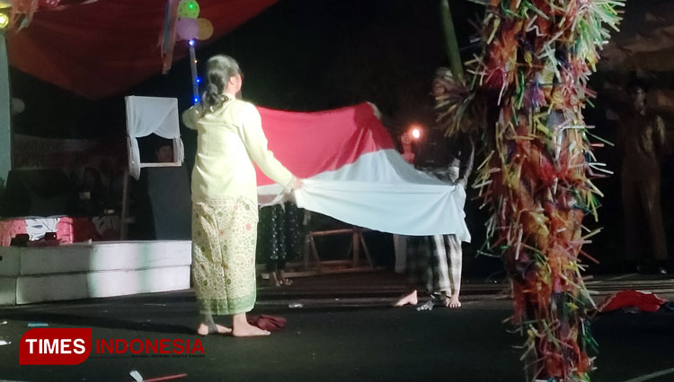 Aki Nden dan Nini Idet yang diperankan oleh Haikal dan Gia membentangkan Bendera Merah Putih dalam pertunjukkan Seribu Sang Saka, Minggu (28/8/22) malam (FOTO: Harniwan Obech/TIMES Indonesia)