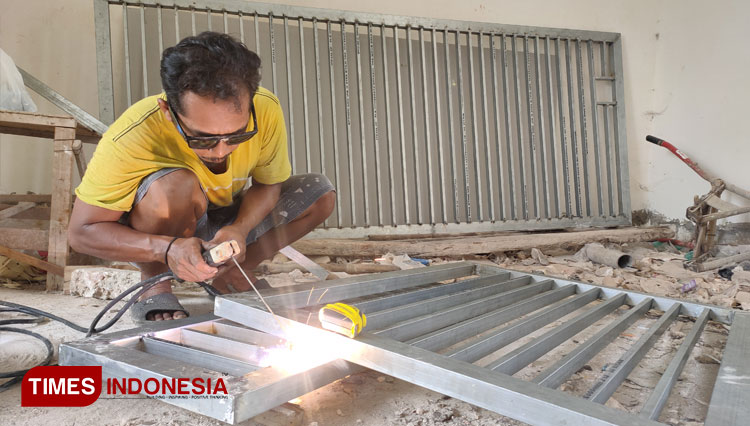 Bengkel pabrikasi, pekerja melakukan pengelasan besi pagar pesanan pelanggan, (Foto: Dok: Safuwan/TIMESIndonesia)