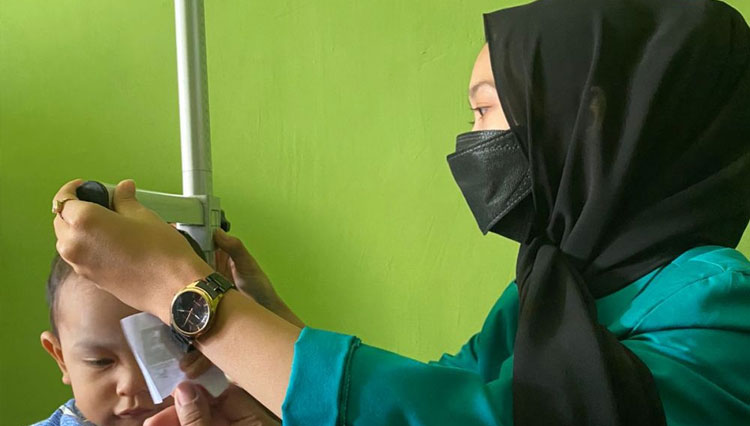 Mahasiswa KSM-T Unisma Malang melakukan pengukuran tinggi badan pada balita. (FOTO: AJP TIMES Indonesia)