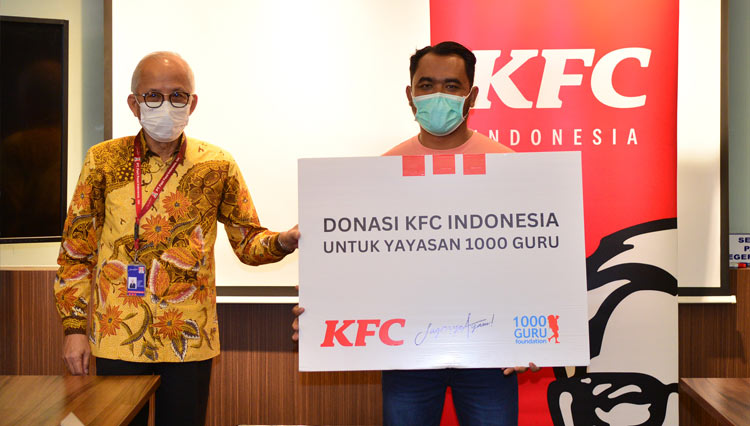 Justinus D. Juwono, Direktur PT Fast Food Indonesia, Tbk menyerahkan Donasi kepada Yayasan 1000 Guru untuk membantu pendidikan anak-anak pedalaman di Indonesia. (FOTO: Dok. KFC Indonesia)