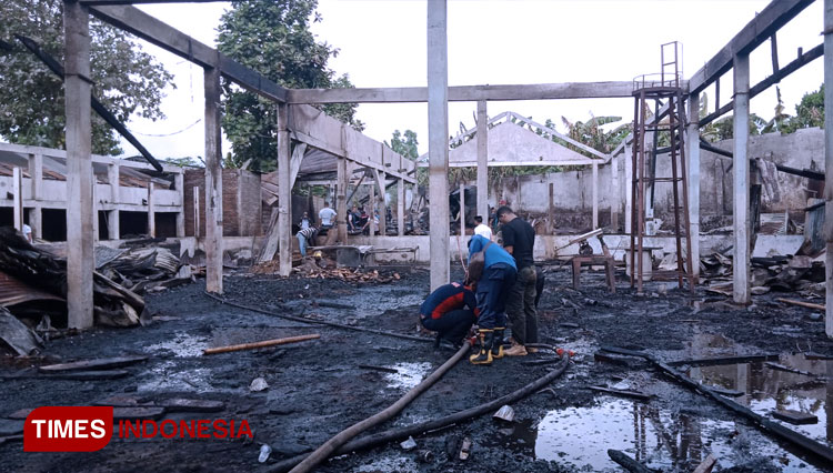 Petugas Damkar sedang melakukan proses pendinginan gudang kayu terbakar di Area PT. Kayu Mas Banyuwangi (Foto: Fazar Dimas/TIMES indonesia)