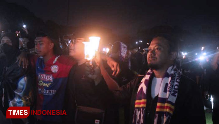 Para suporter menyalakan lilin sebagai tanda berkabung bagi korban Tragedi Stadion Kanjuruhan (FOTO: Yobby/TIMES Indonesia)