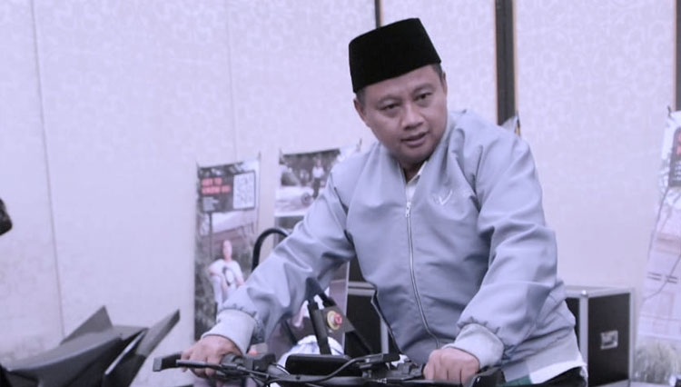 Wakil Gubernur Jawa Barat, Uu Ruzhanul Ulum, sedang menaiki motor yang dipamerkan di acara West Java Investment Summit (WJIS) 2022, Bandung. (Foto Humas Jabar)
