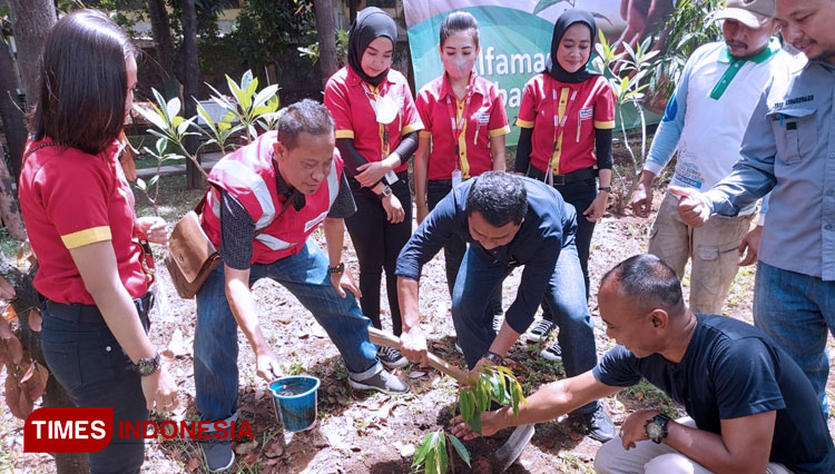Regional Corcom Manager PT Sumber Alfaria Trijaya (SAT) Mochammad Faruq menyerahkan bibit durian yang ditanam diPogar Urban Forest, Kecamatan Bangil, Pasuruan, Jawa Timur, Jumat (7/10/2022). (FOTO: Alfamart for TIMES Indonesia)