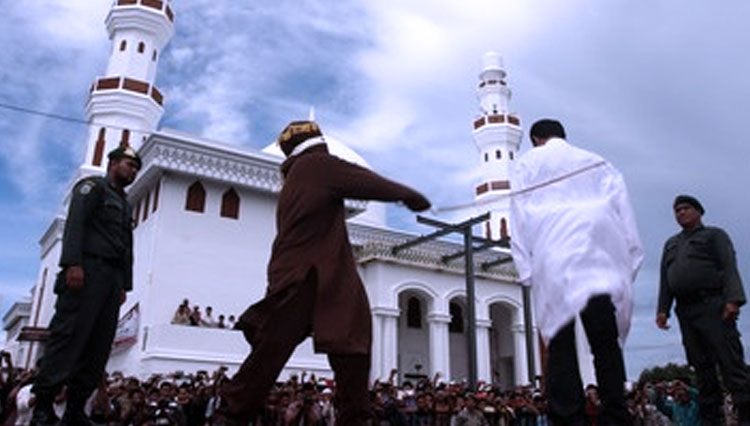 Algojo saat mengeksekusi hukuman cambuk kepada terpidana kasus perjudian di Provinsi Aceh. (FOTO: Antara/Irwansyah Putra)