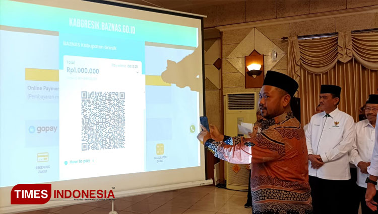 Bupati Gresik Fandi Akhmad Yani saat mensimulasikan pembayarna zakat non tunai (Foto: Akmal/TIMES Indonesia).
