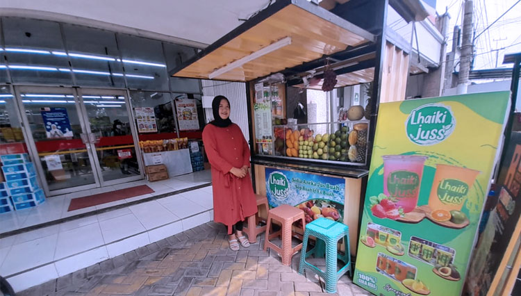 Desy Noraini, pemilik Lha Iki Jus, di depan salah satu lapaknya yang menempati halaman salah satu toko Alfamart diTulungagung. (FOTO: Alfamart)
