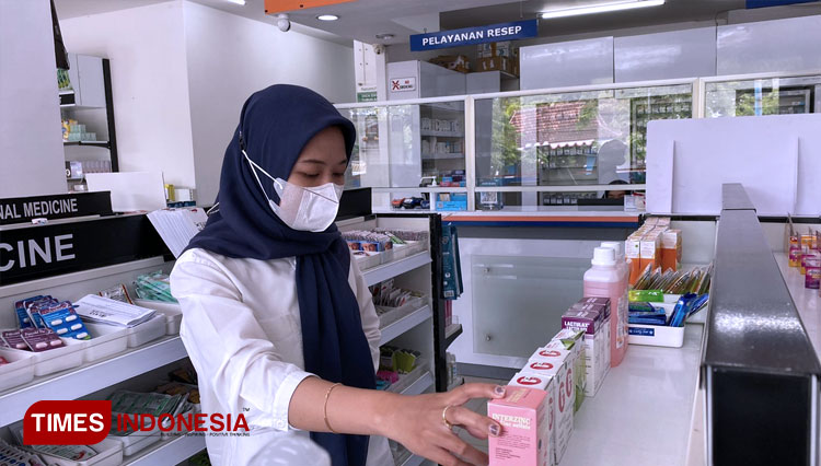 Pelanggan Apotek di Banyuwangi sedang memilih Obat Sirup yang diizinkan Kemenkes. (FOTO: Fazar Dimas/TIMES Indonesia)