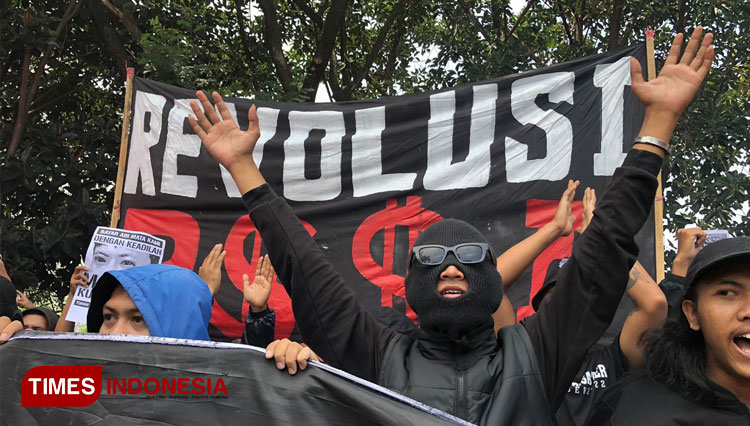 Massa aksi saat membentangkan poster PSSI Revolusi dalam kegiatan demo tragedi Kanjuruhan beberapa waktu lalu. (Foto: Rizky Kurniawan Pratama/TIMES Indonesia)